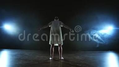 穿着白色短裙的现代女舞<strong>女表</strong>演漂亮的塑料戏剧舞蹈，穿过舞台，摔倒